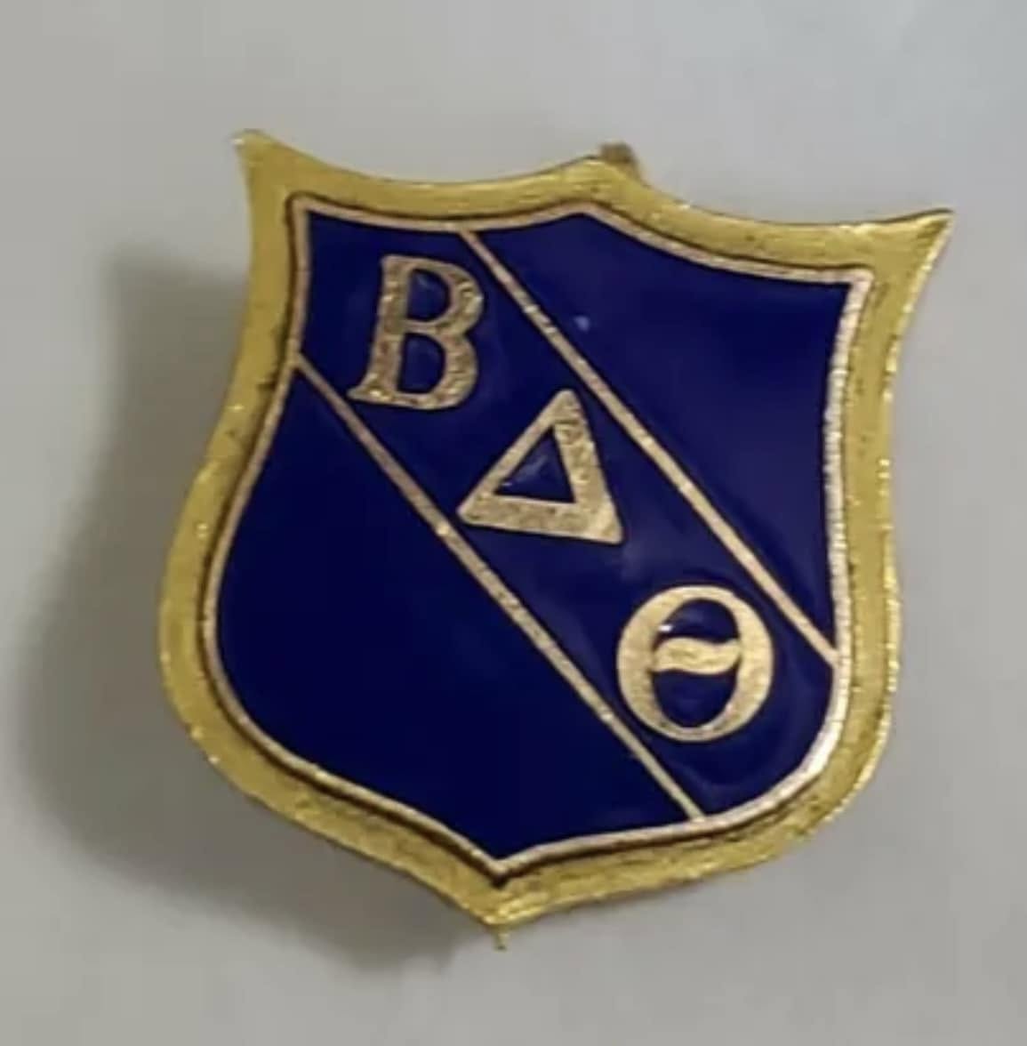 Original Beta Delta Theta founding fraternity pin — the blue and gold shield worn by the men who would become Sigma Nu's Theta Lambda Chapter